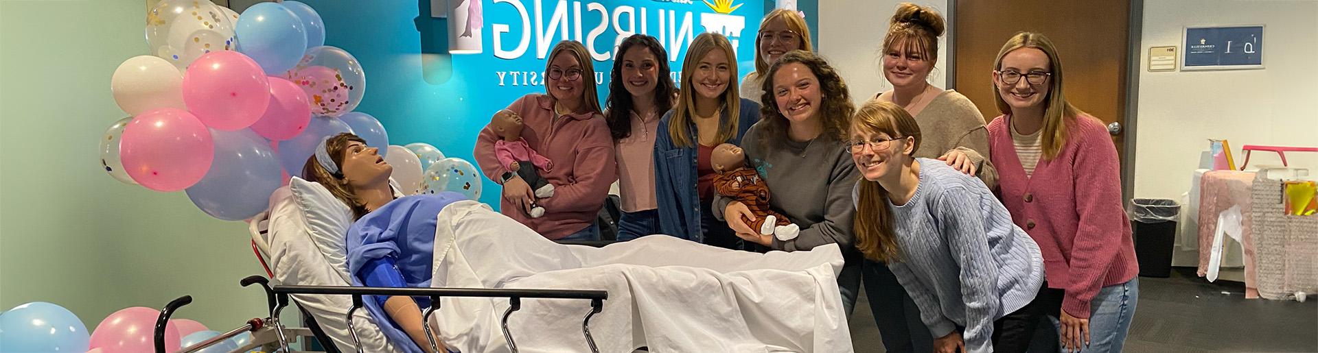 Nursing students throw a baby shower for the programs new manikin with gifts going to help a local crisis pregnancy resource center.